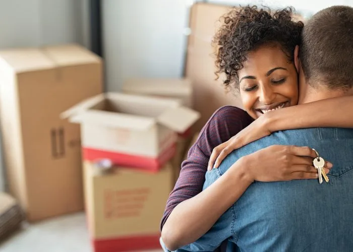 Woman hugging man and holding home keys
